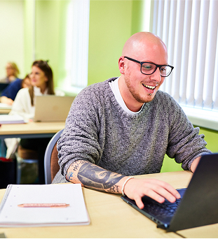 A student typing on a laptop.
