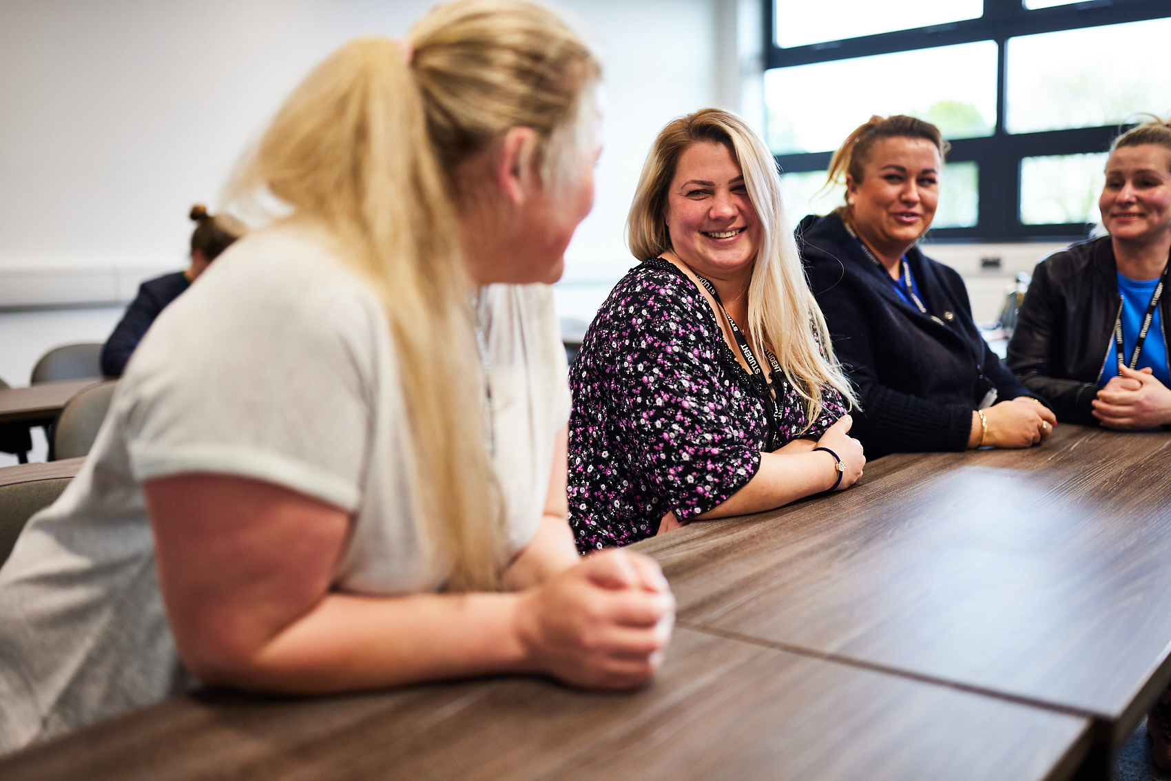 Group of students talking at a desk.