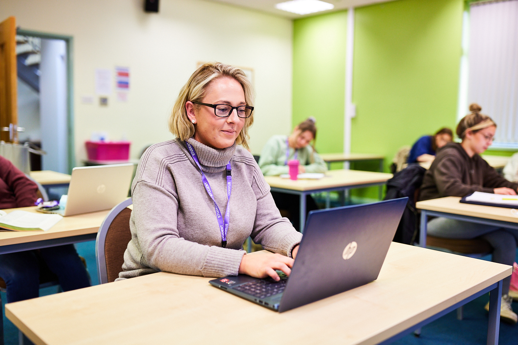 Student working on their laptop in a classroom.