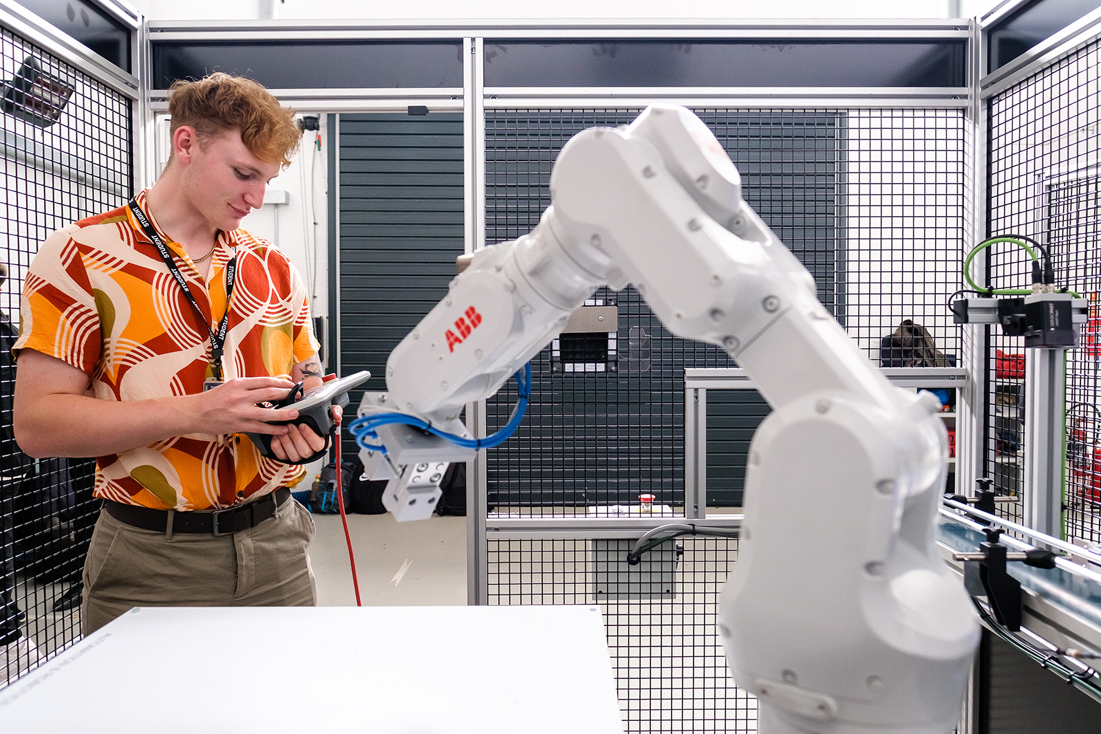 A student works a robotic arm using a digital tablet in the Digital Technologies workshop.