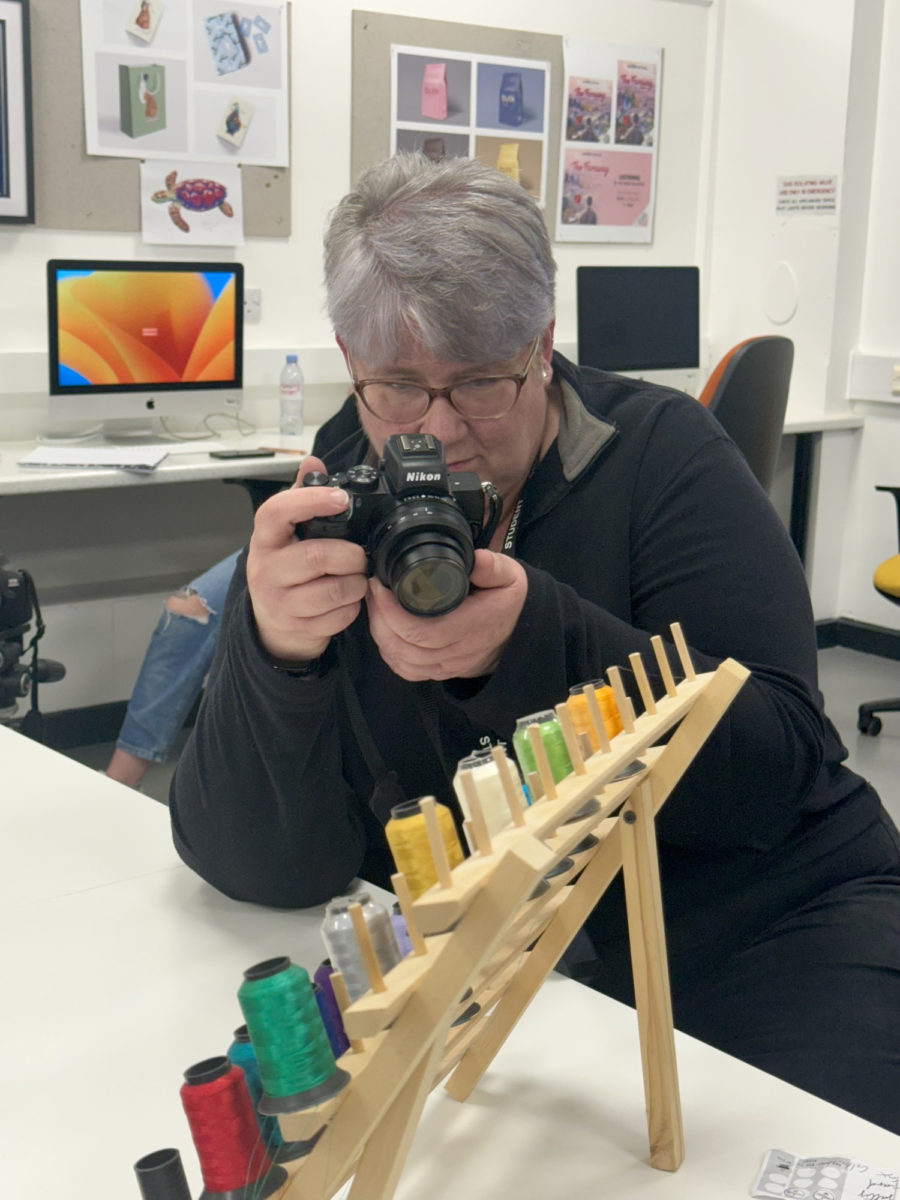 A student photographing a textile reels.