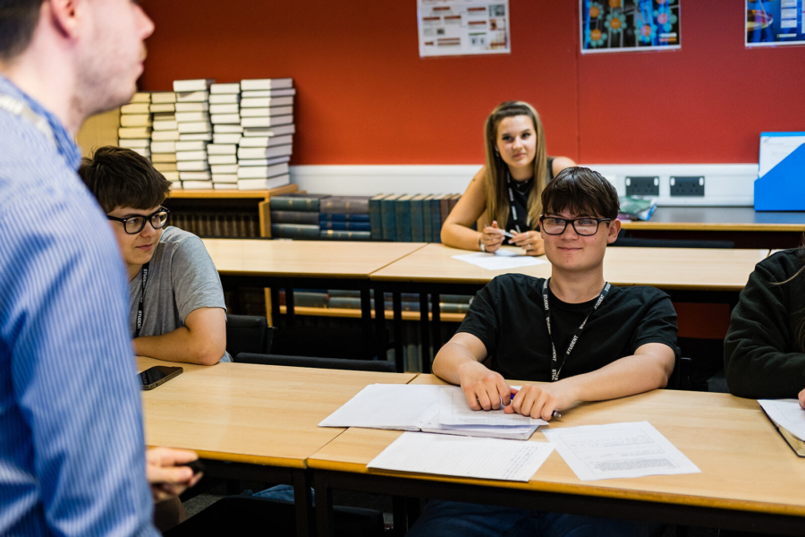 A student listening to a lecturer teaching in class.