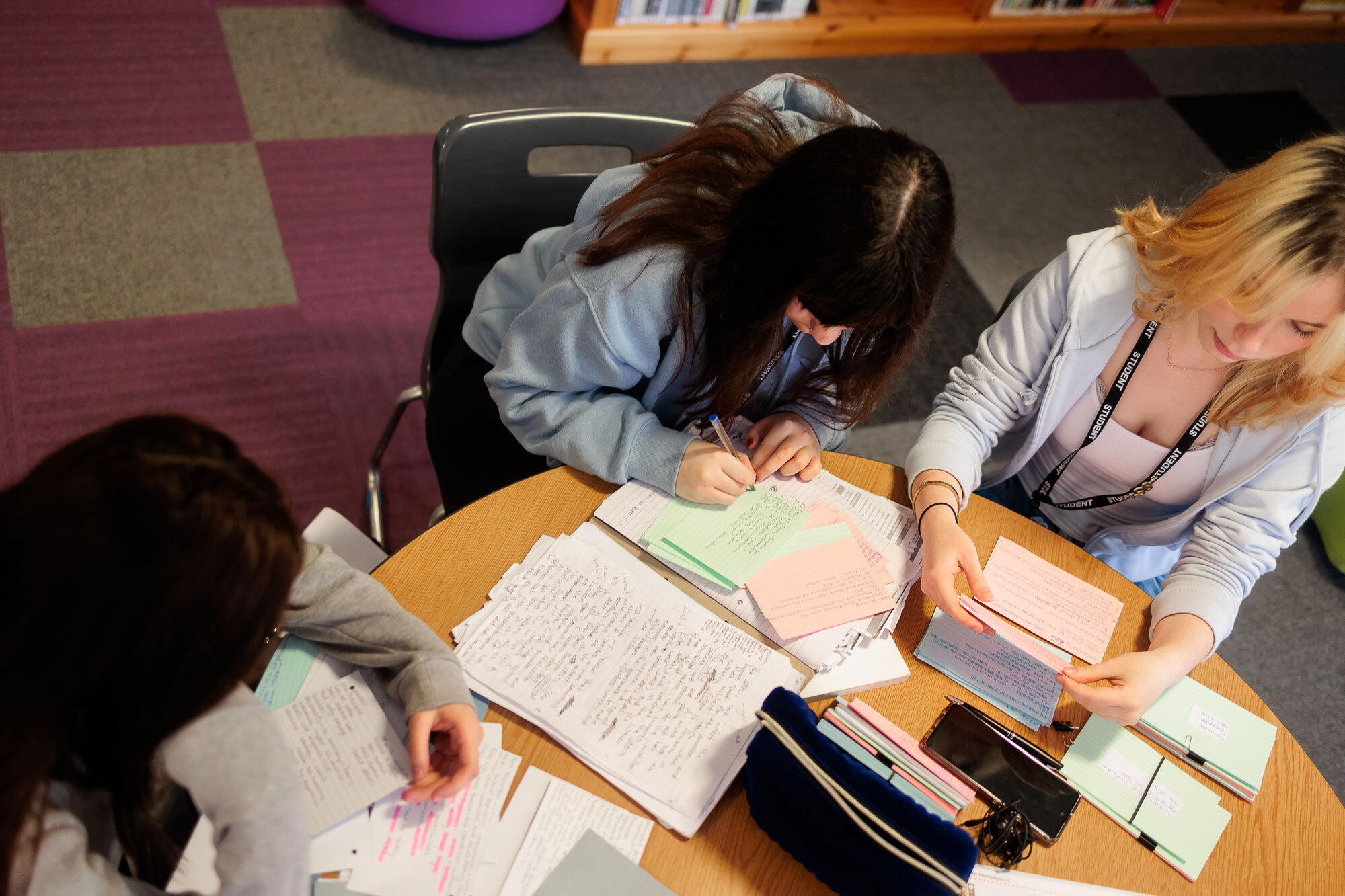 Students sat writing notes around a table.