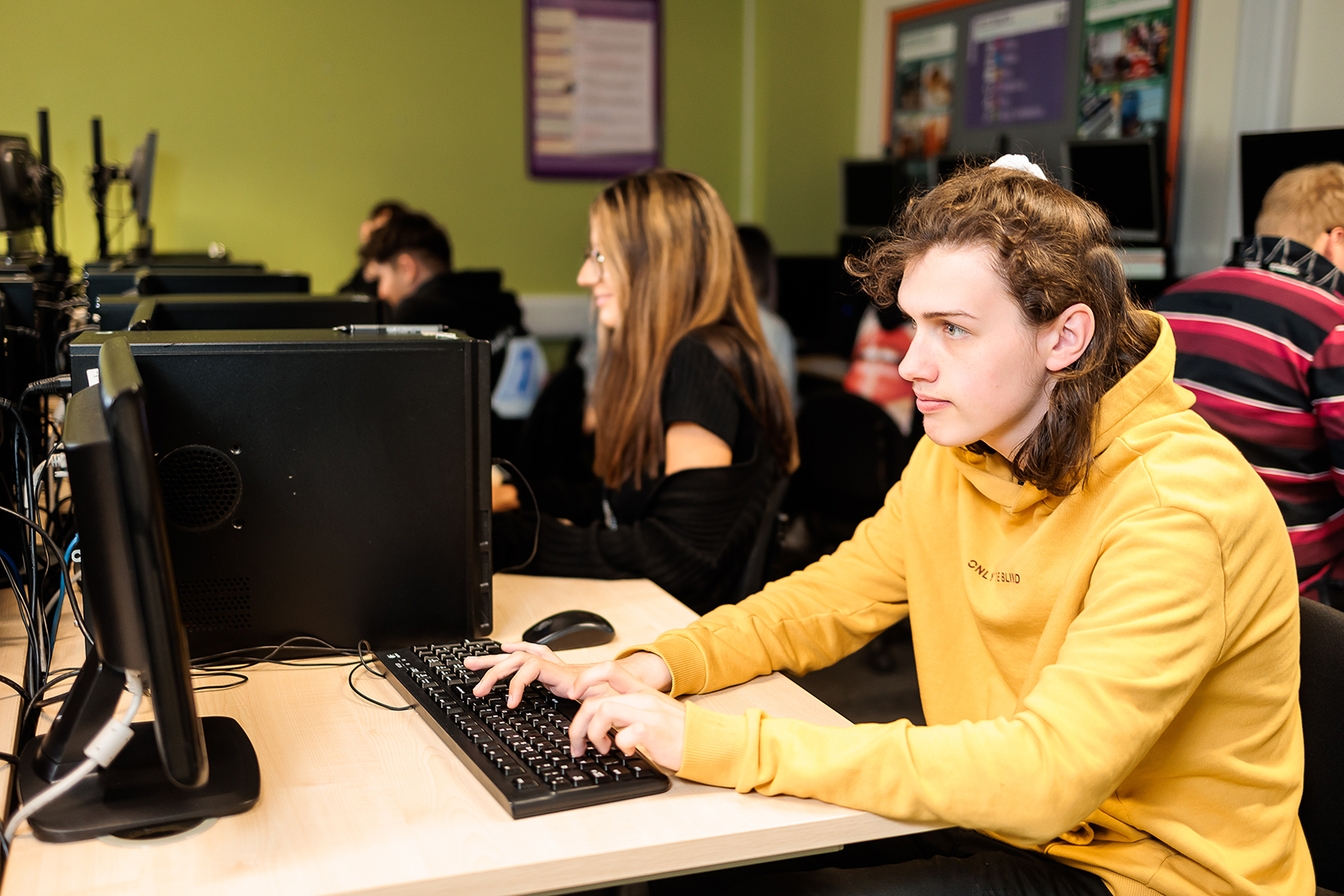 A student typing at a computer.