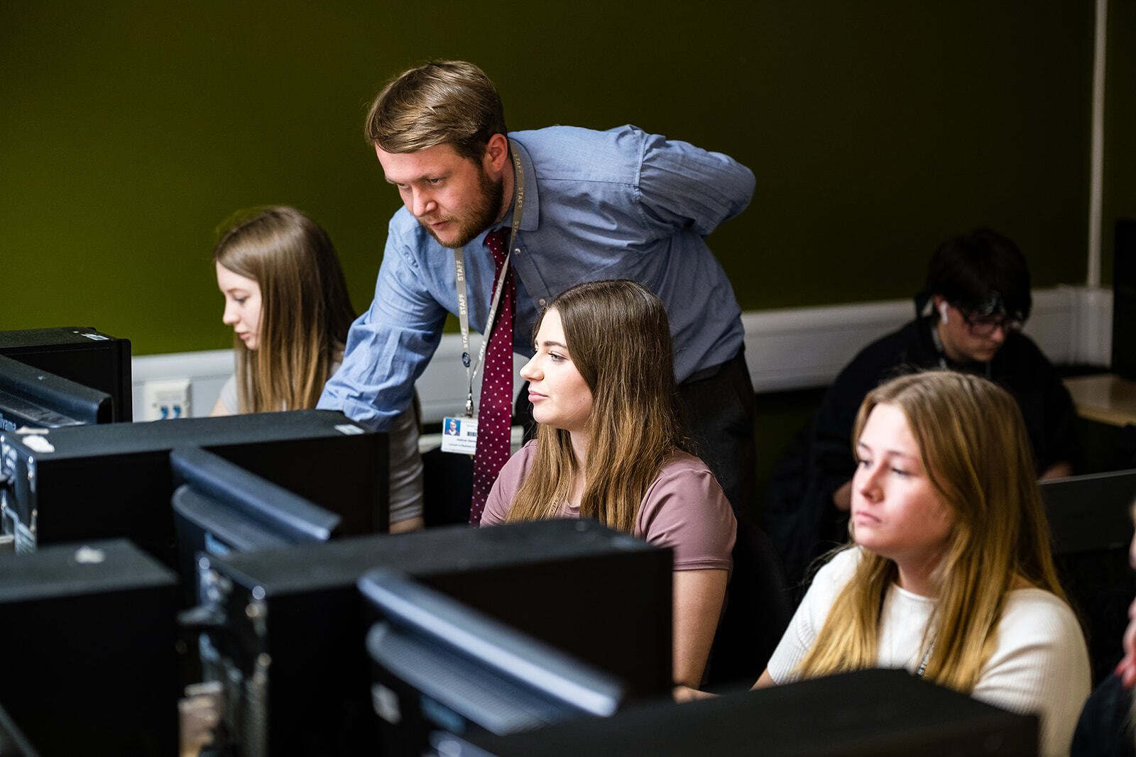 Students being taught by a lecturer in a computer suite.