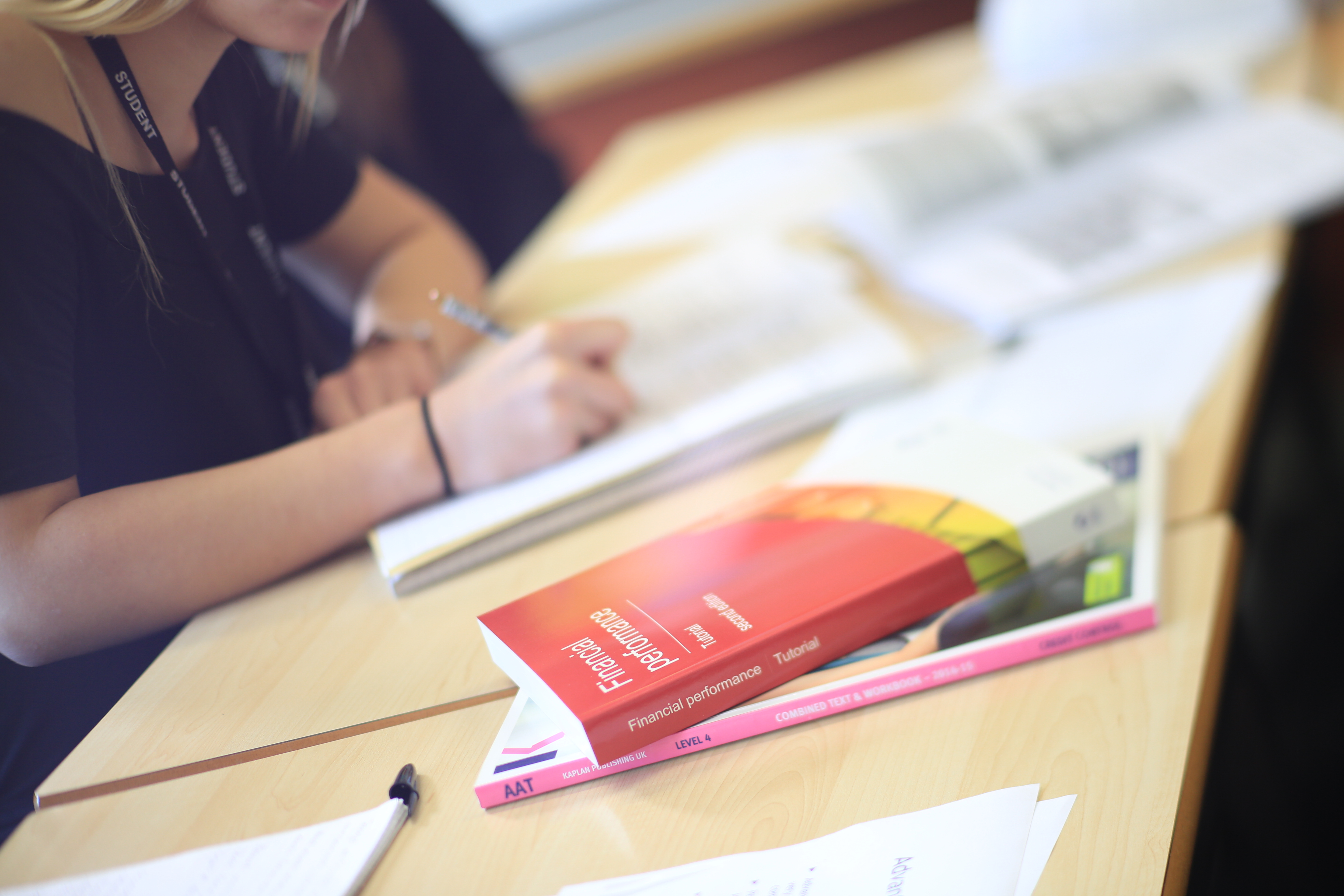 A student writing notes behind resource books.