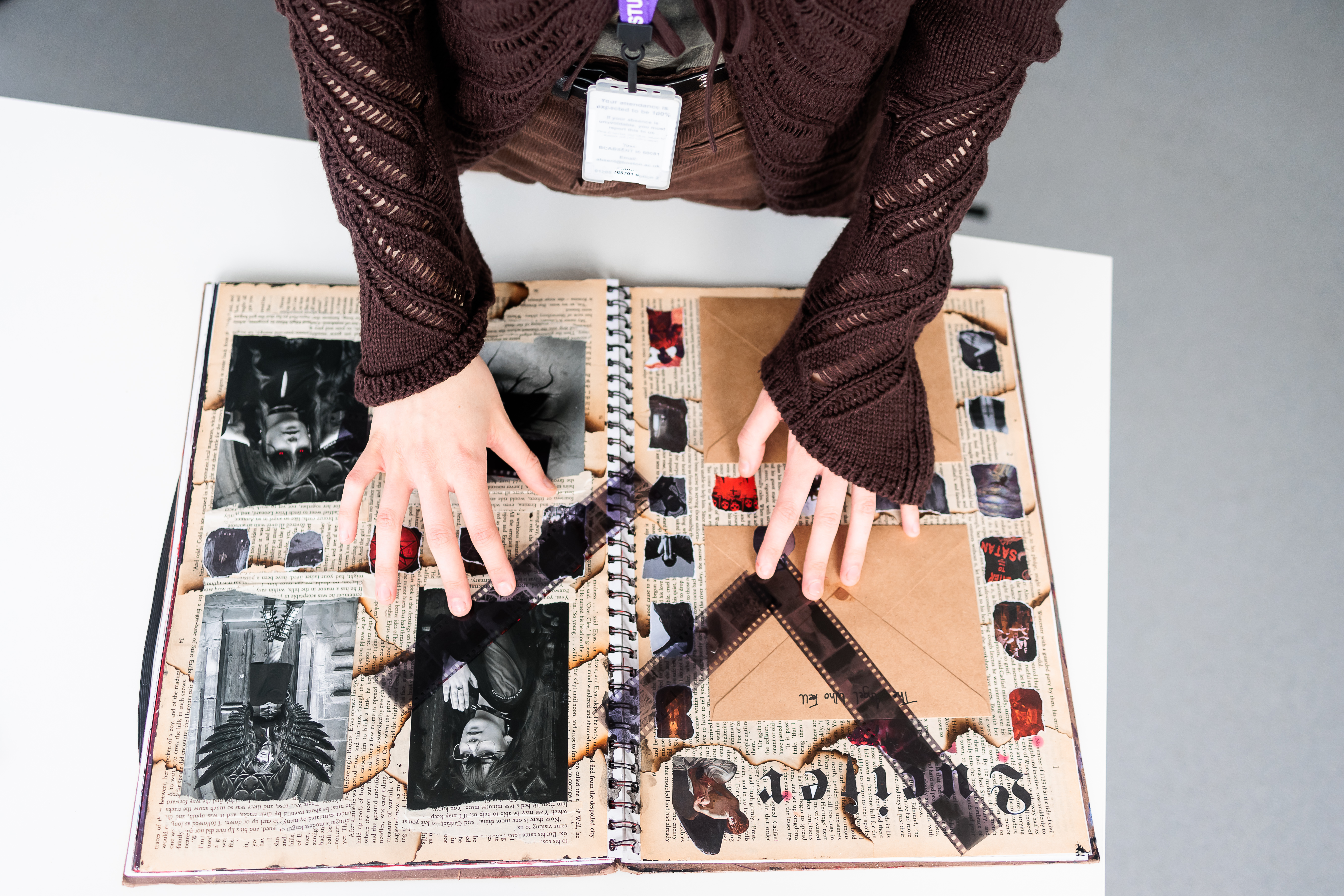 Student sticking artwork into a sketchbook.