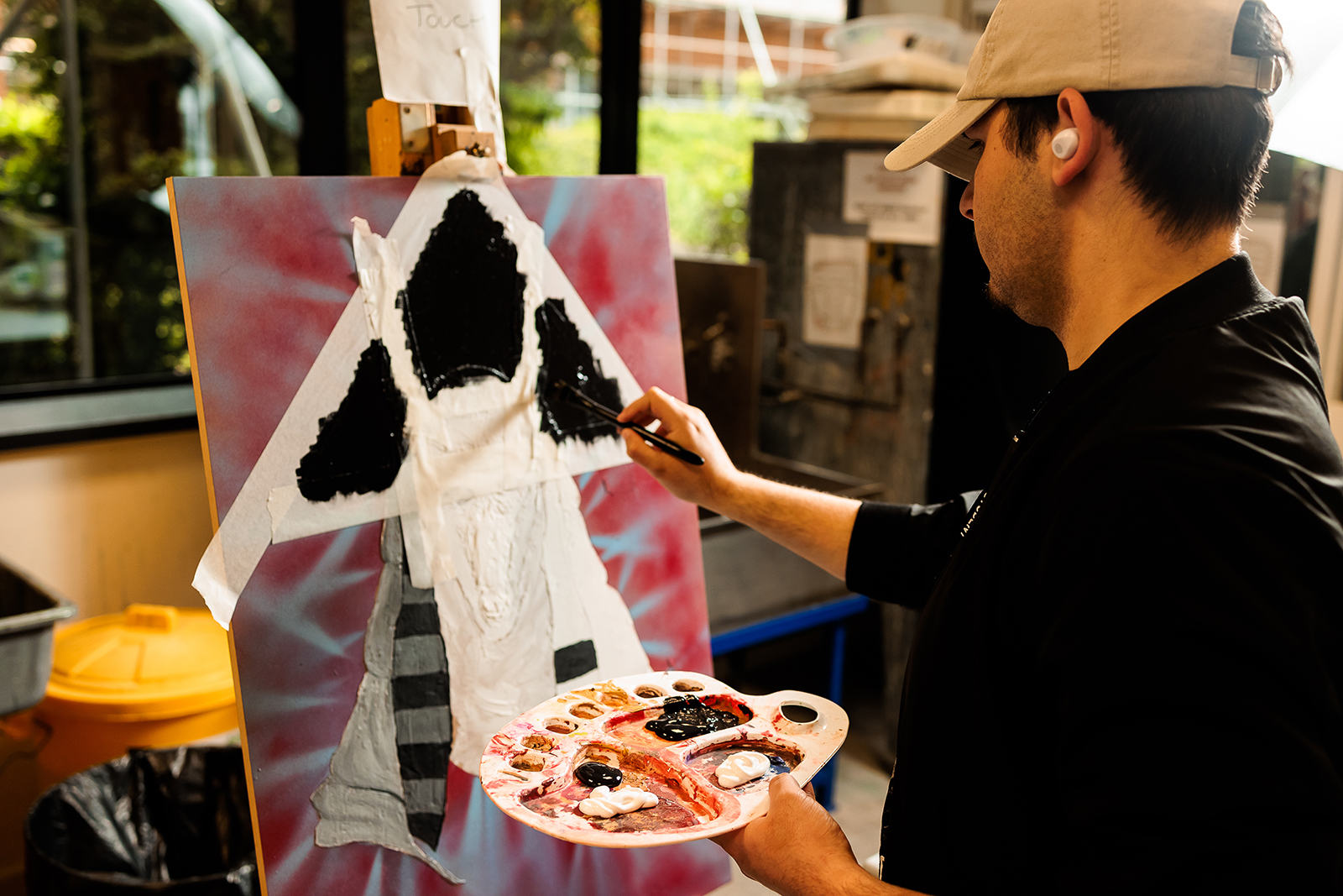 Student paining on an easel.
