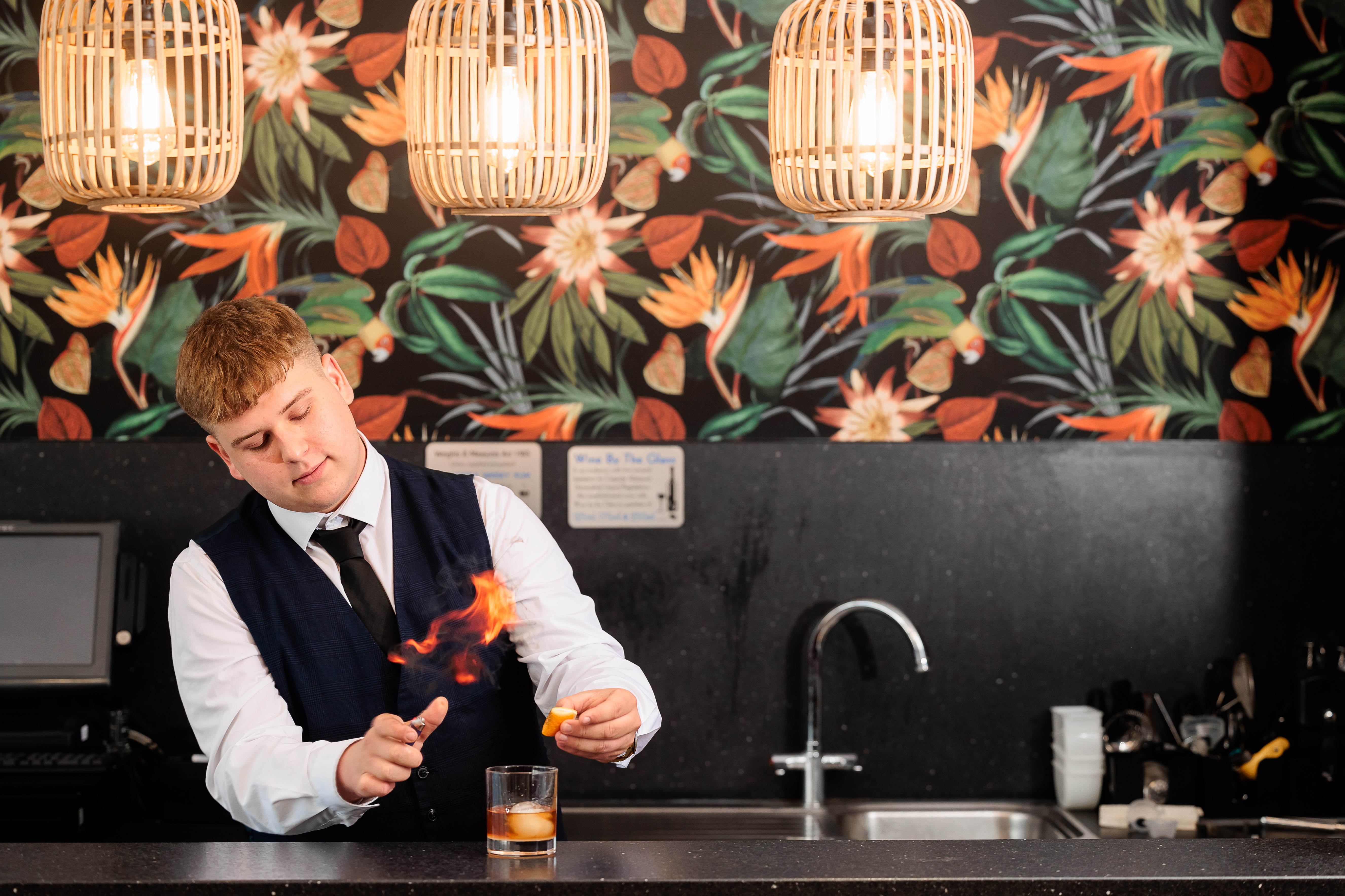 Student making cocktails in a kitchen.