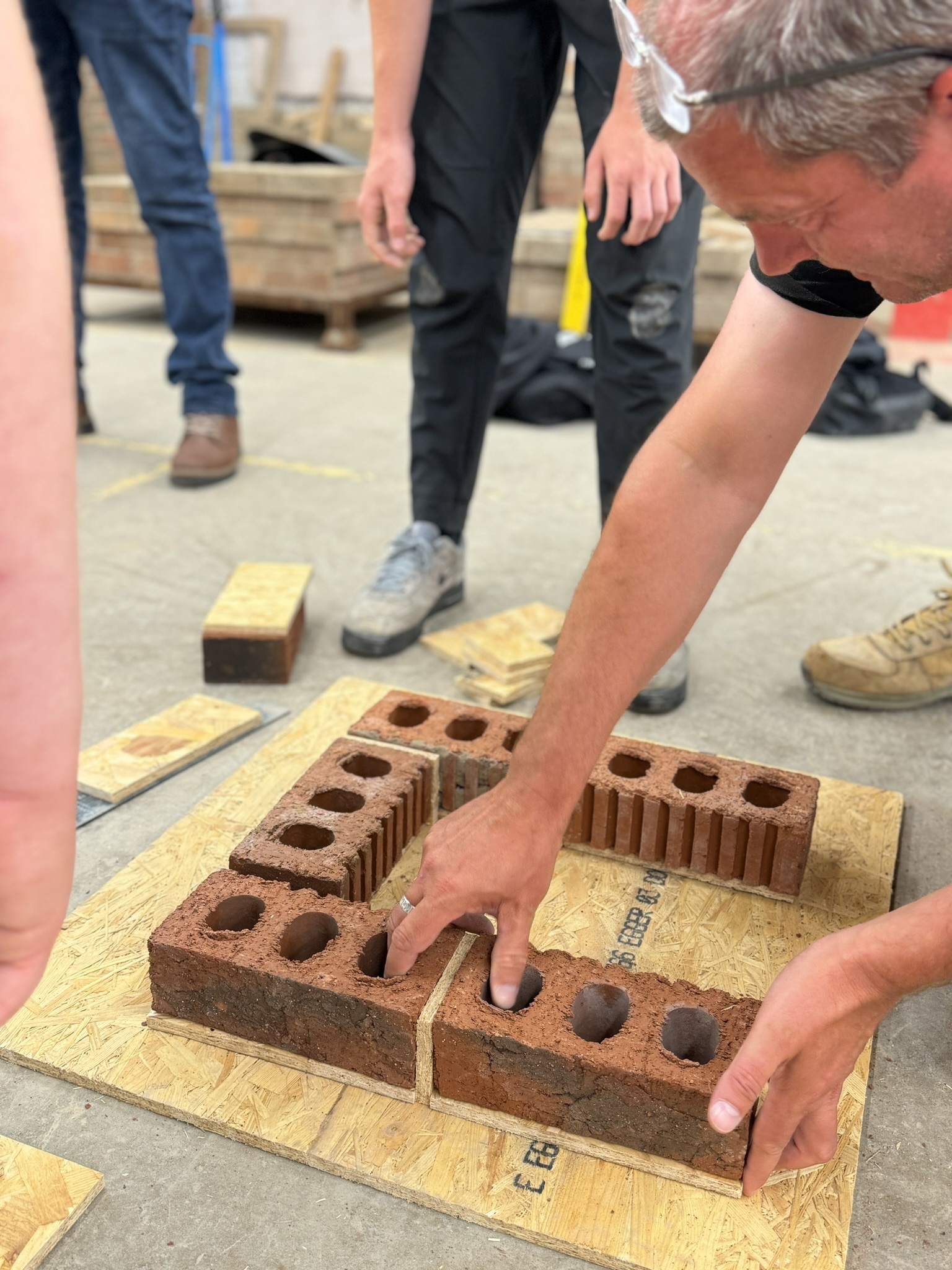 A person laying bricks down on the floor.