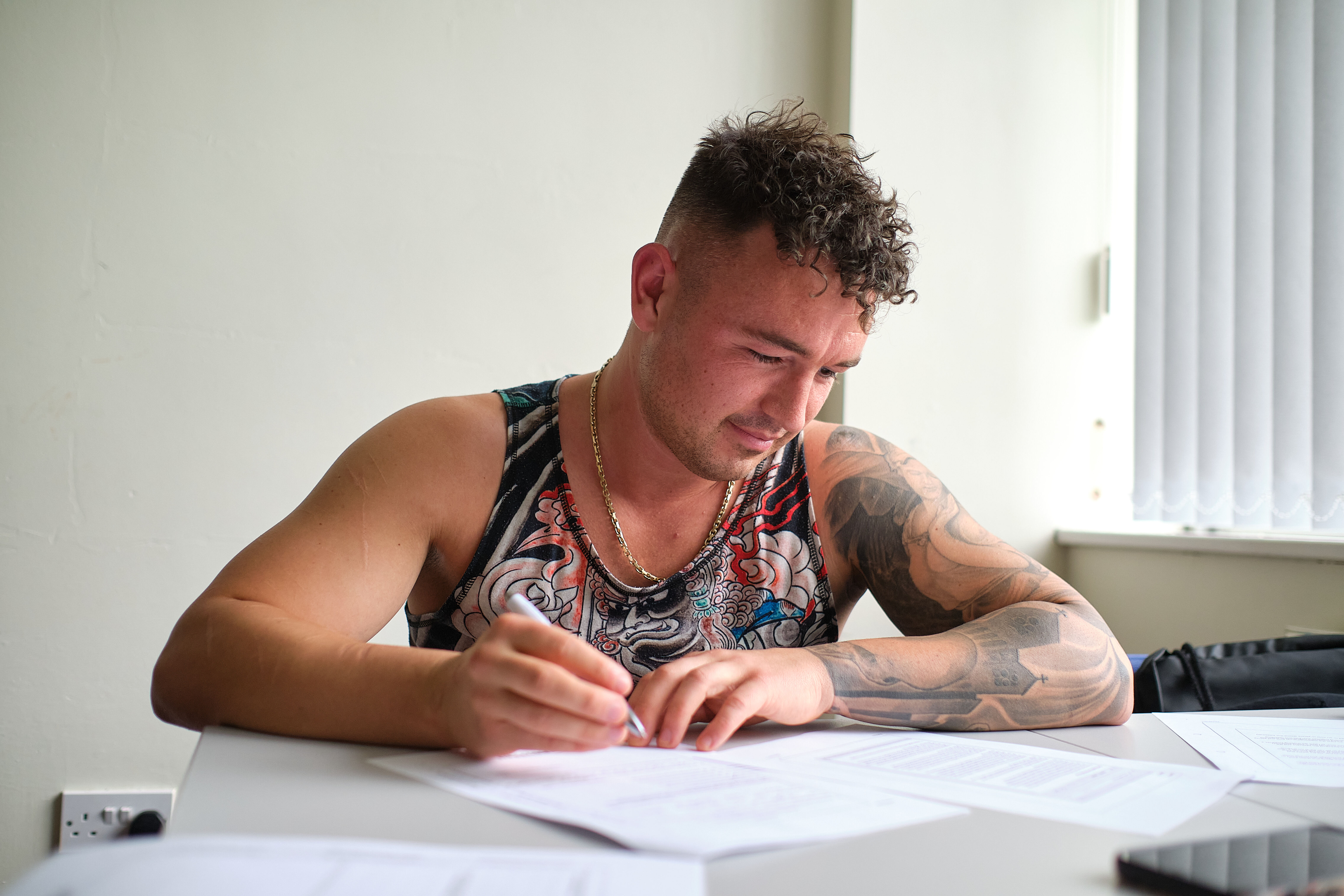 A student sat at a desk writing.