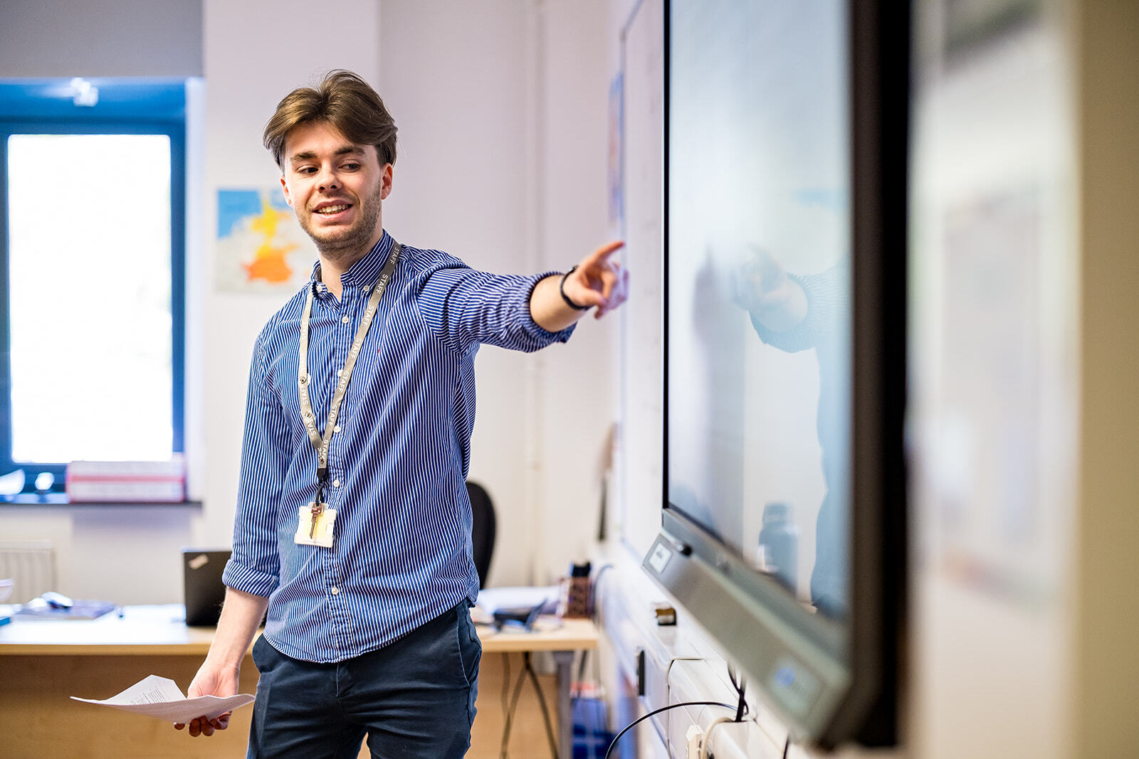A lecturer pointing at a whiteboard.