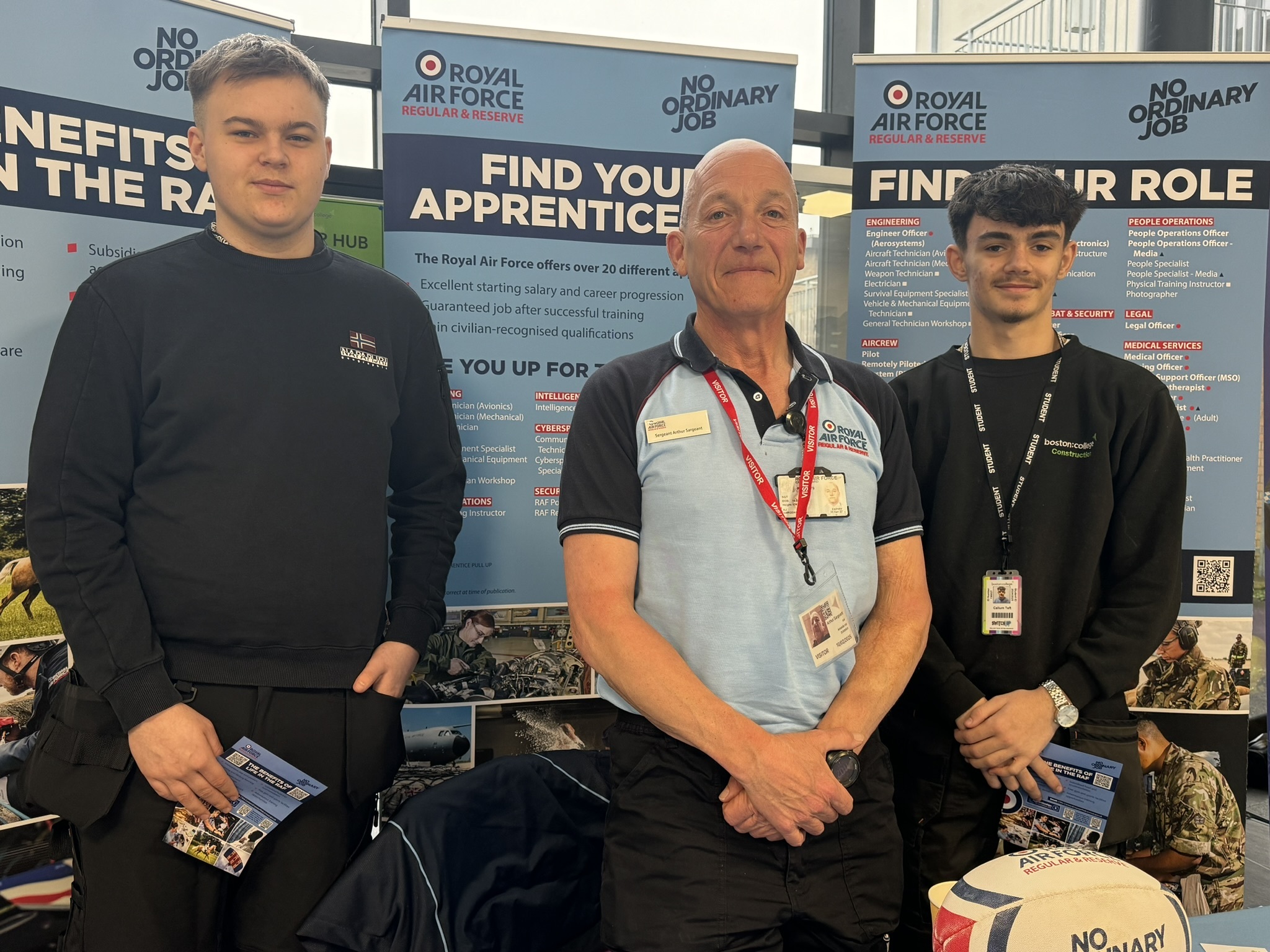 Two students with an Royal Air Force representative at an event.