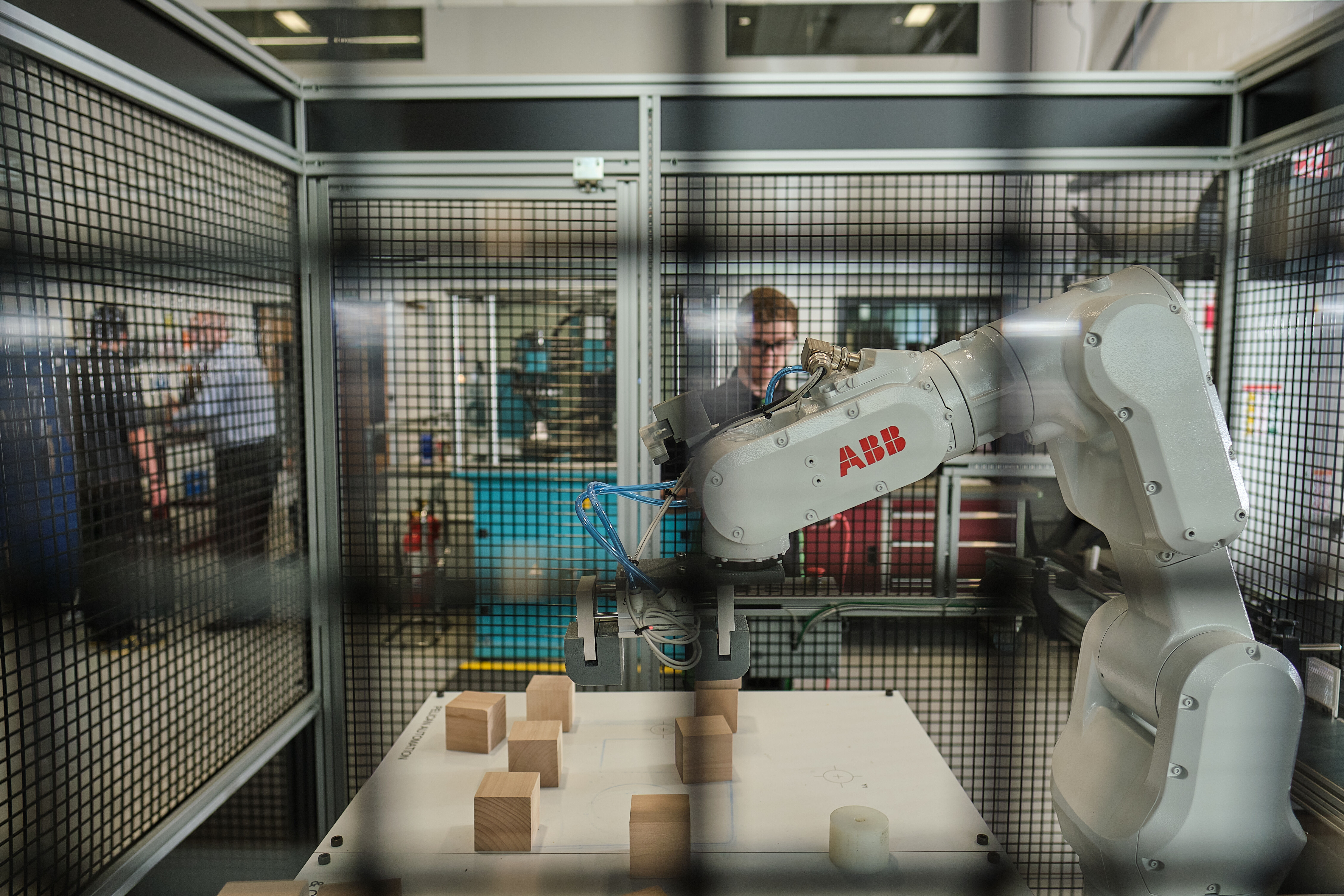 A student observing a robotic arm at work.