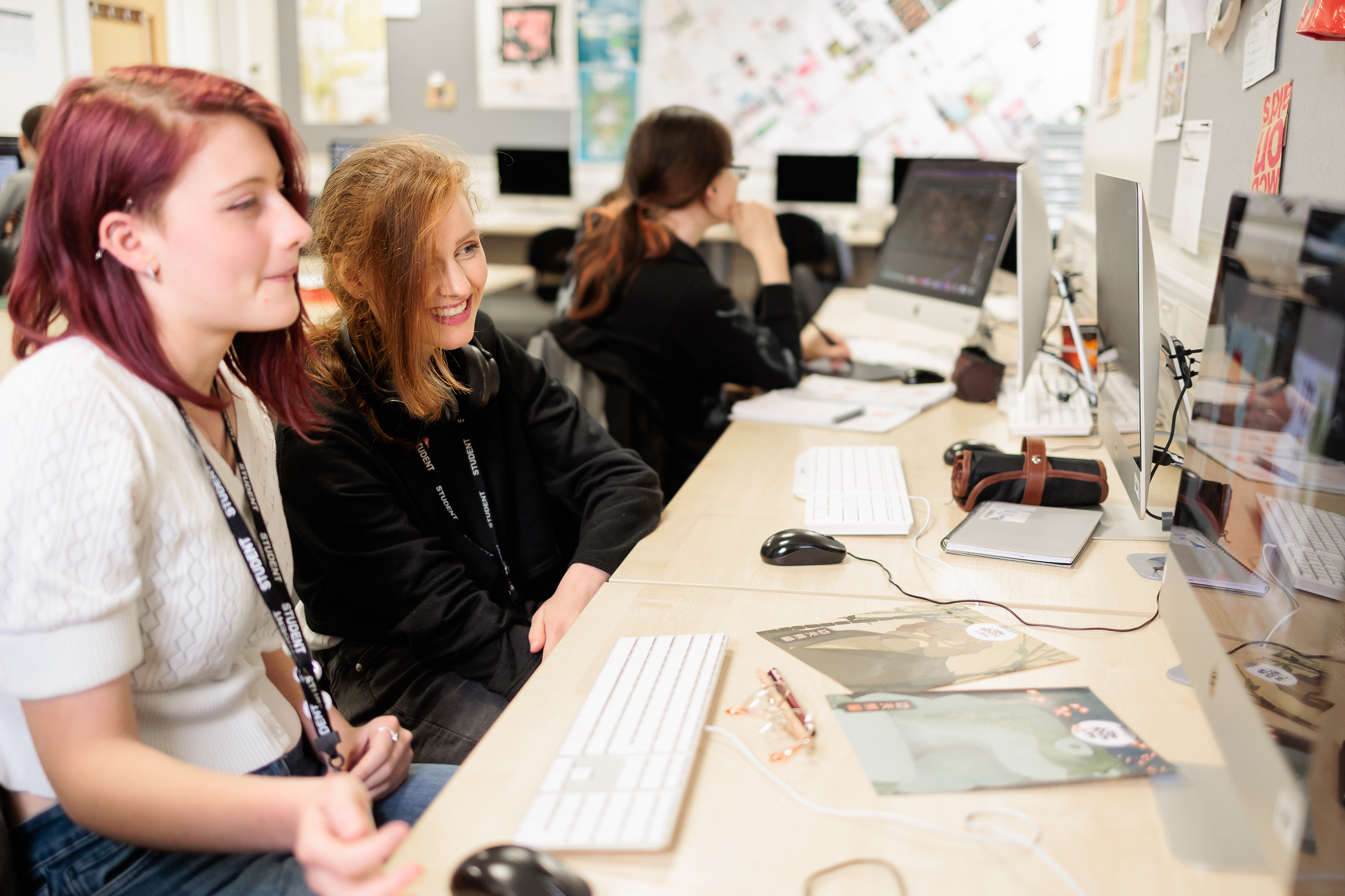 Two students looking at work on a computer screen.