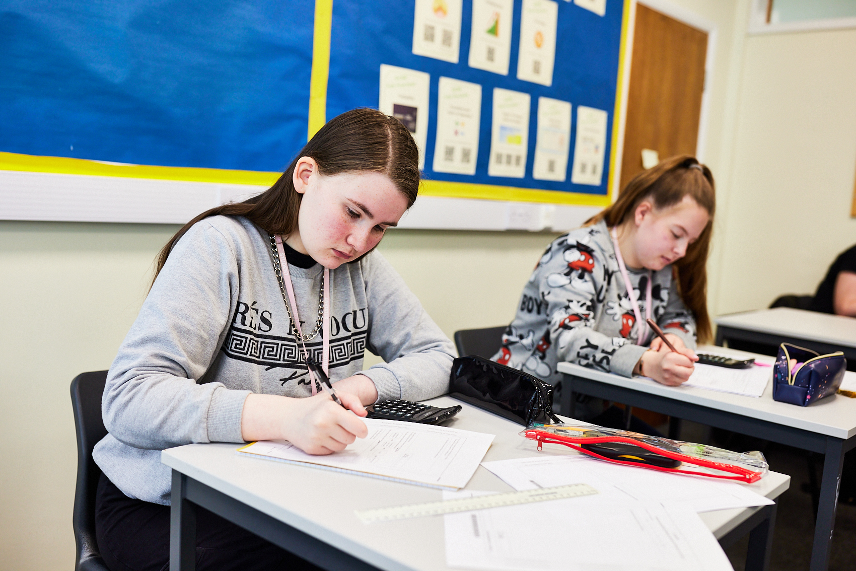 Two students sitting a Maths exam.