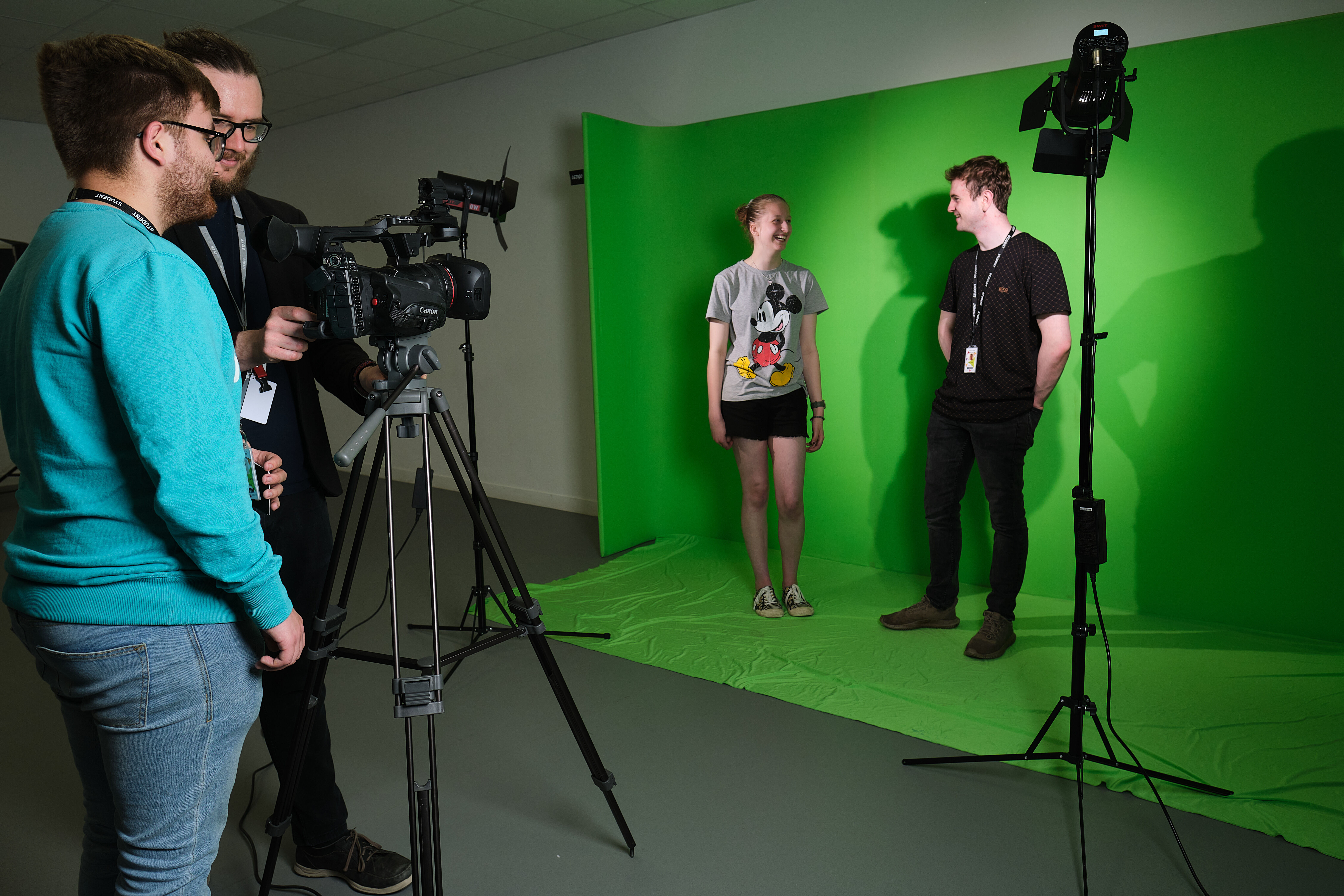 Students filming a production in the TV studio with lighting and greenscreen.