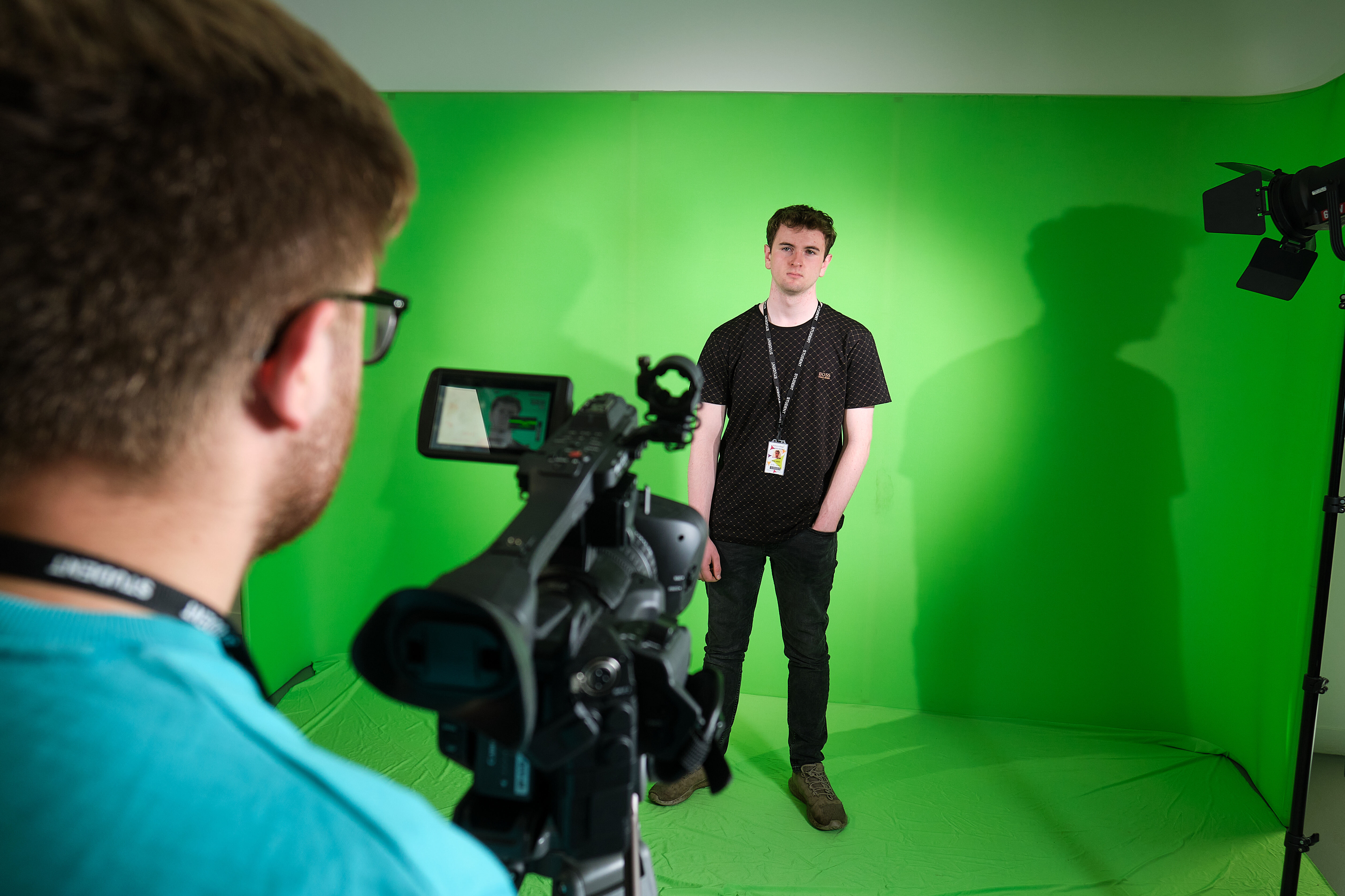 Students filming a production in the TV studio with lighting and greenscreen.