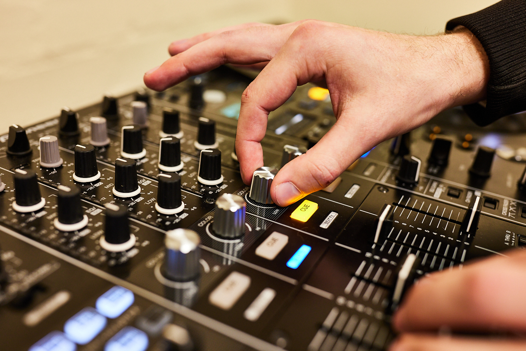Hands turning a dial on a DJ Deck.