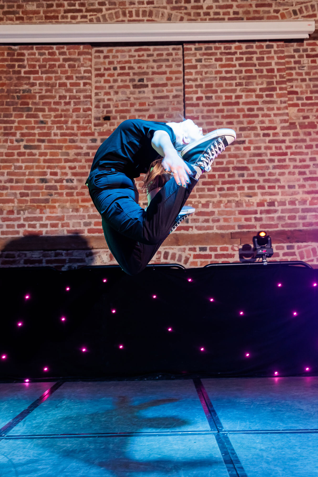 A student jumping in the air while performing a ballet routine.
