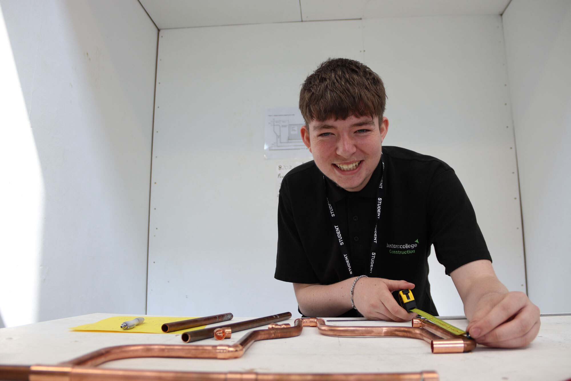 A student looking up from their work to smile at the camera.