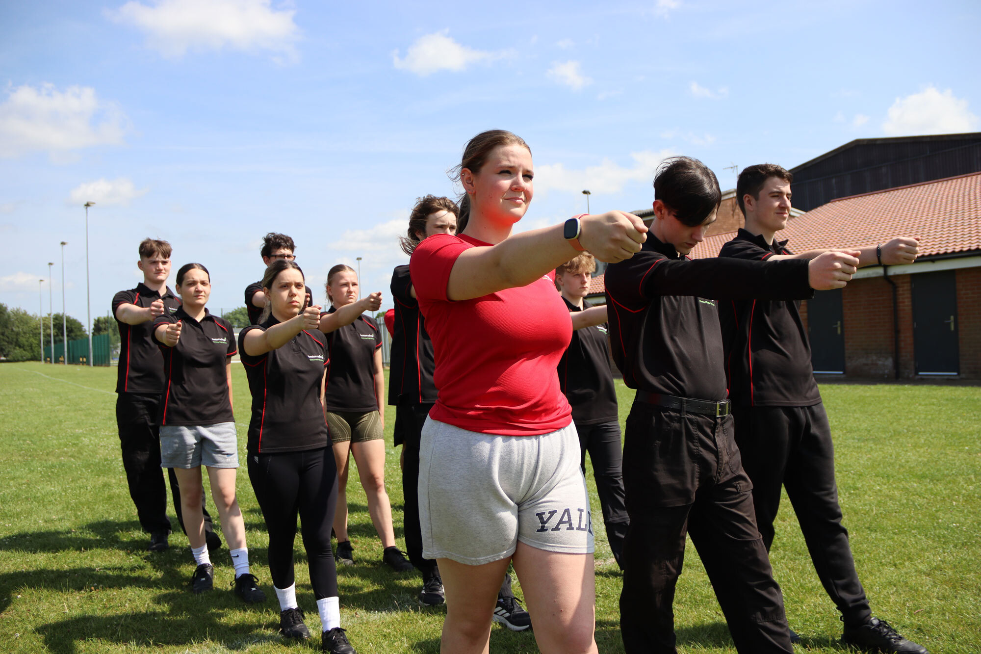 Students marching on a grass field.