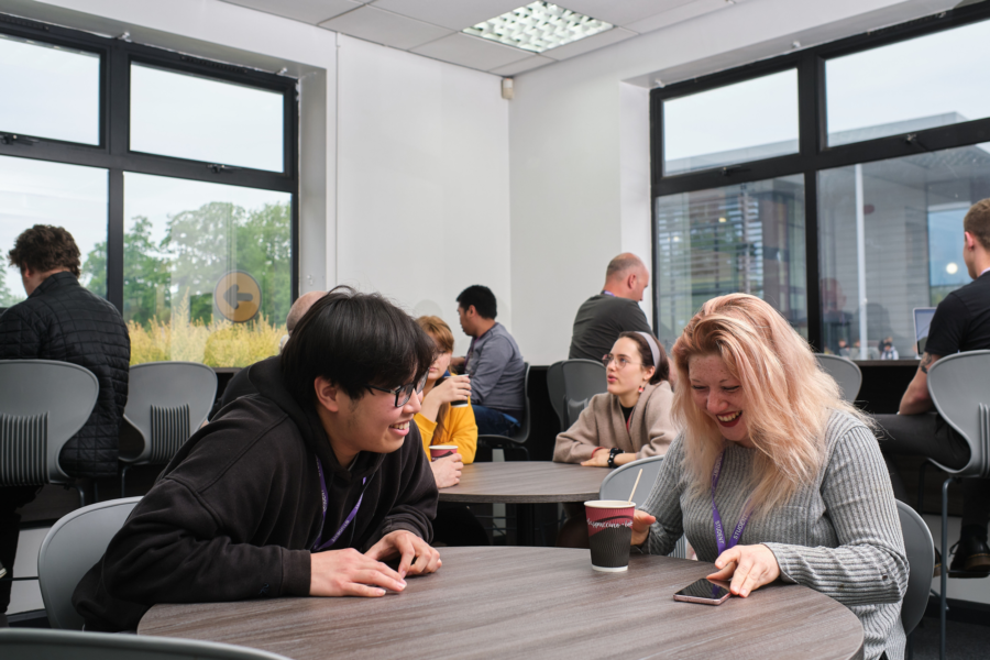 Adult learners sat around tables chatting.
