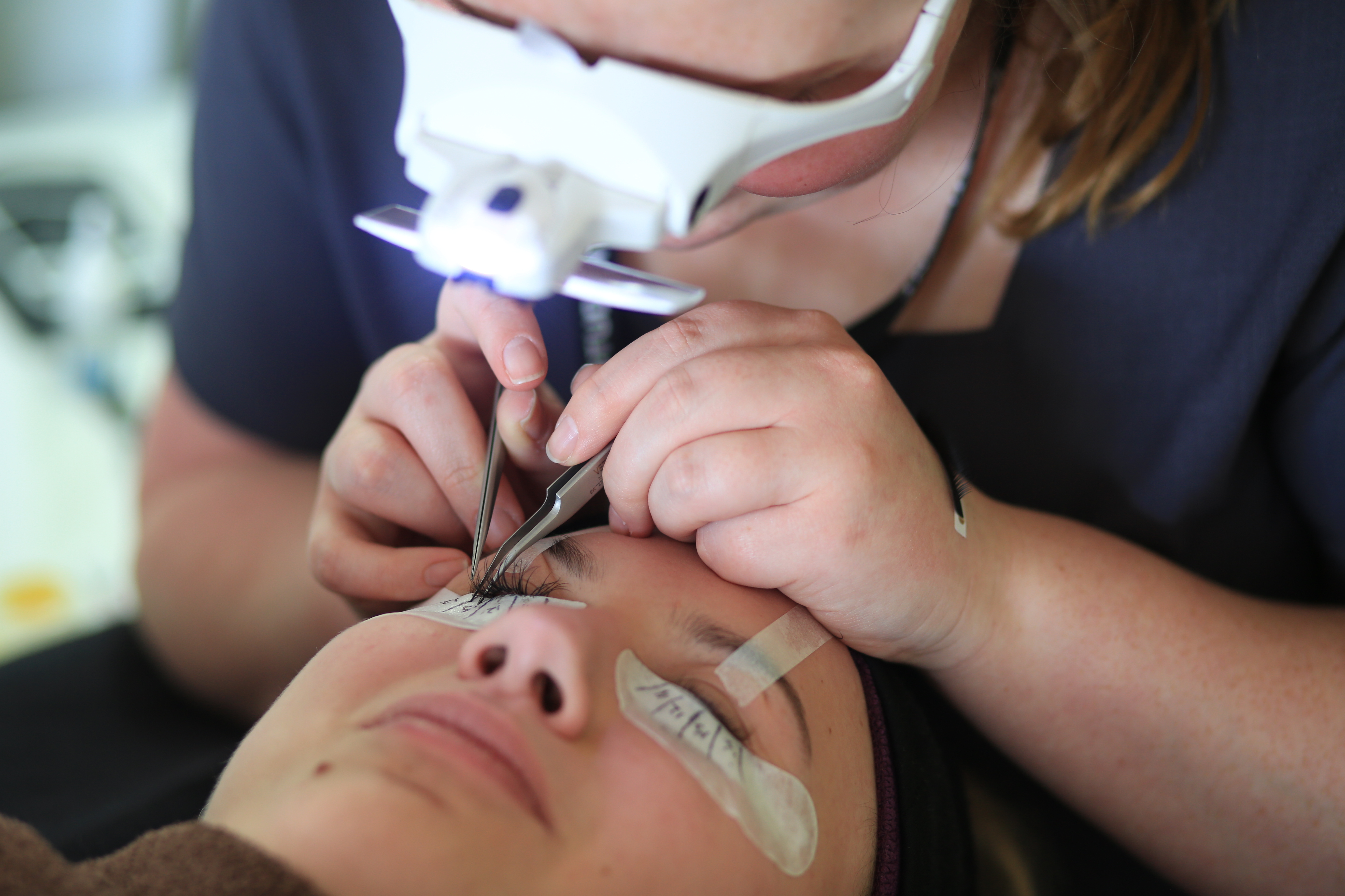 Student performing a facial beauty treatment.