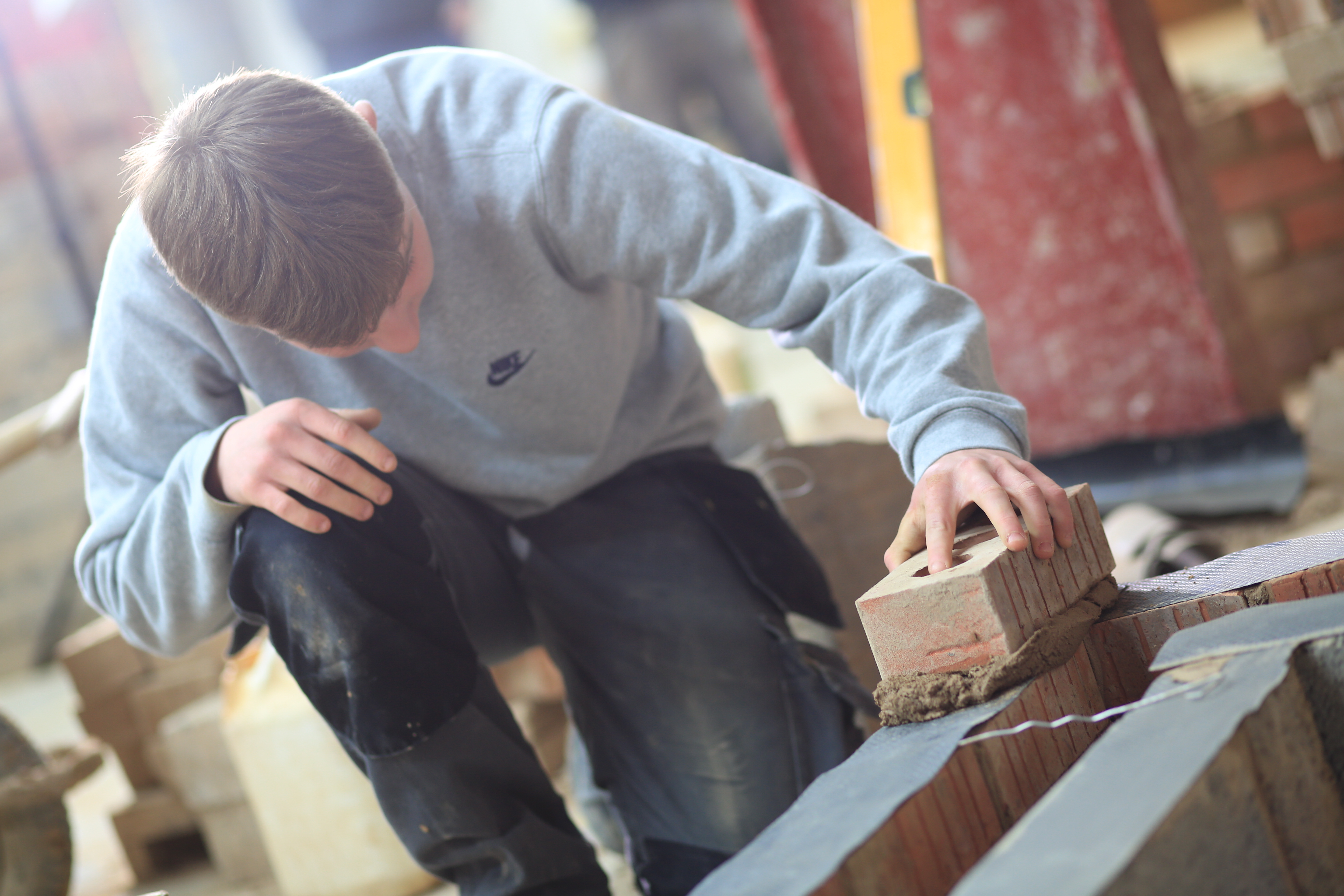 A student building a brick wall.
