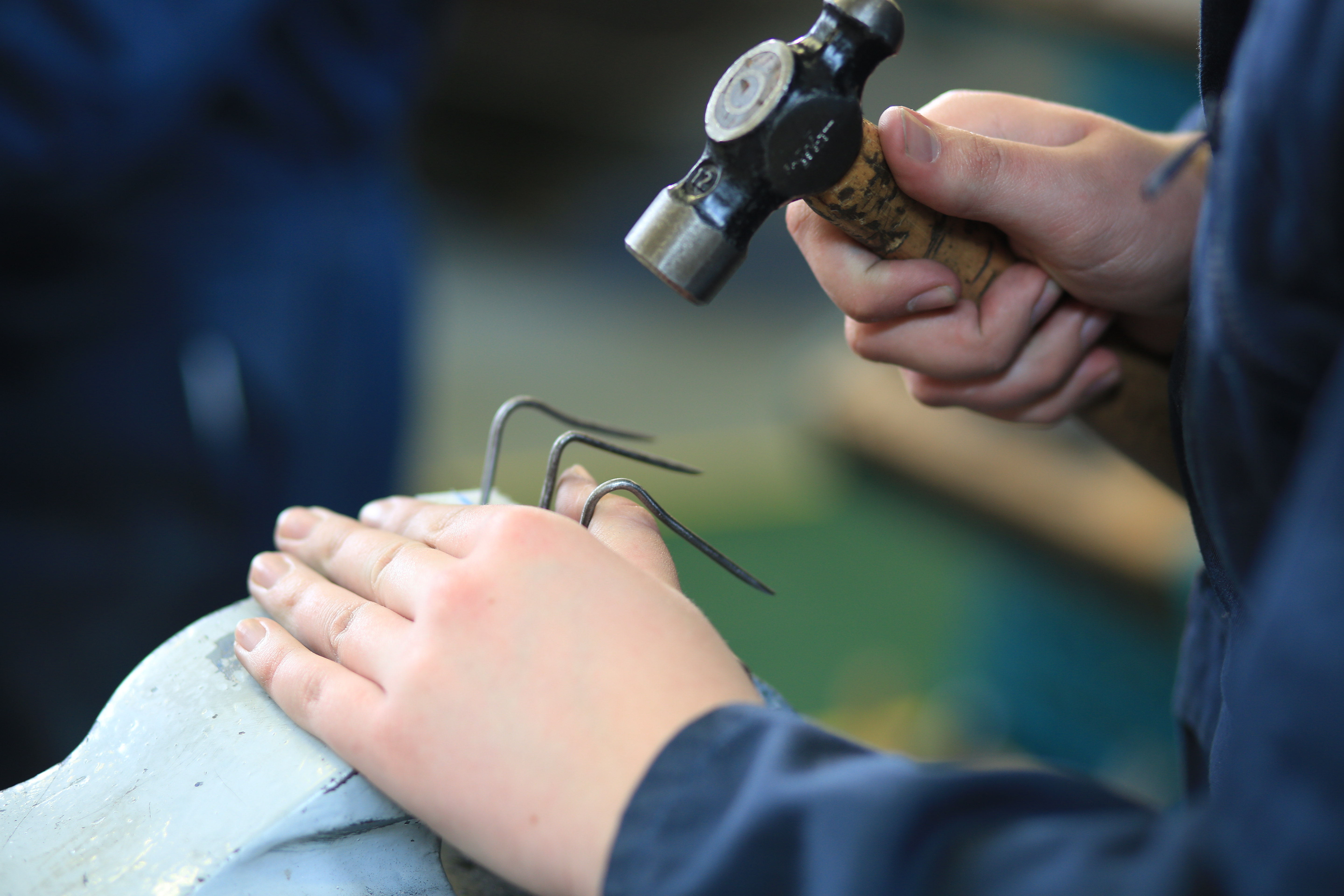 Nails being hammered into an object.