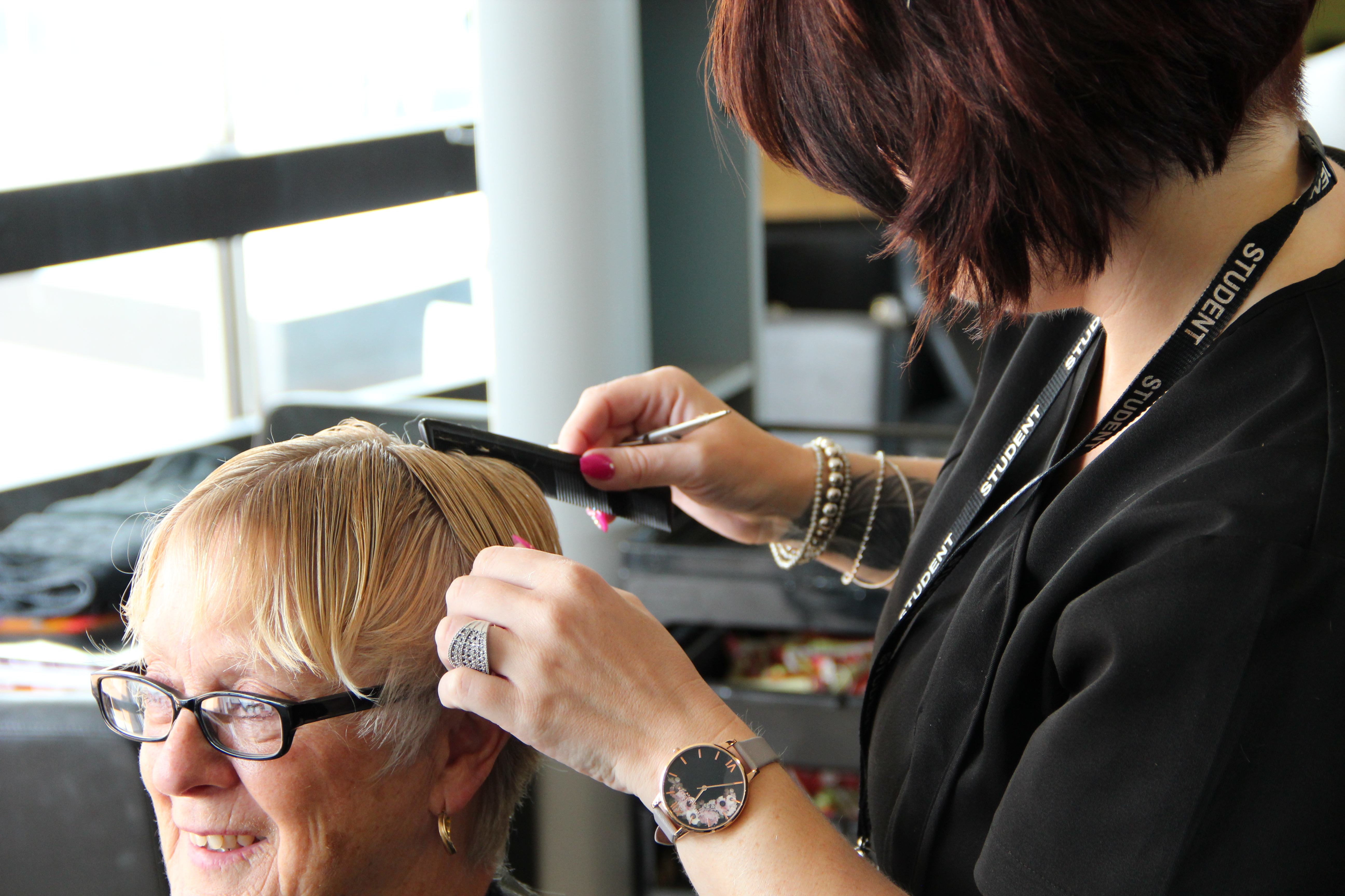 A student cutting a customers hair in the salon.