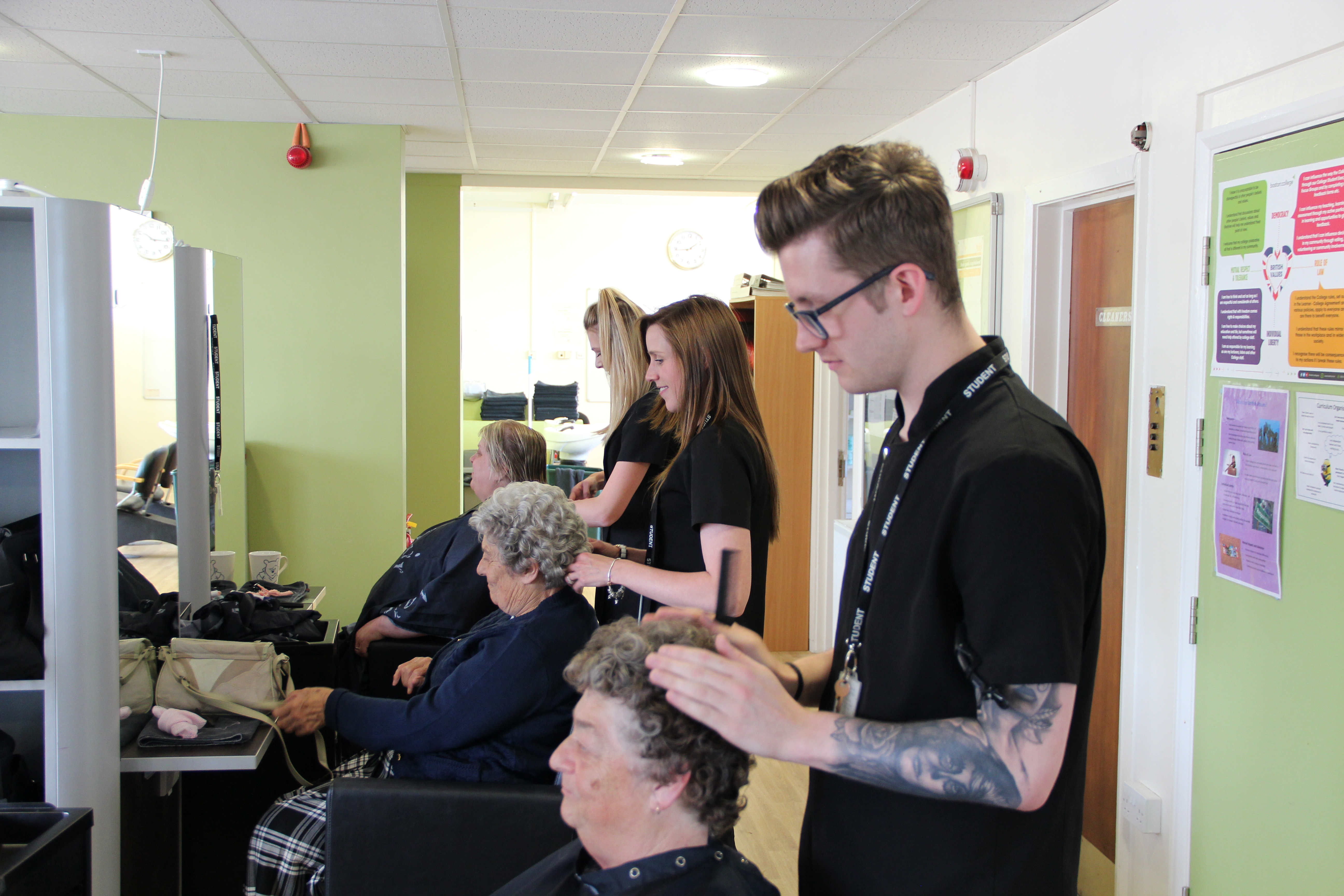 A students cutting customers hair in the salon.