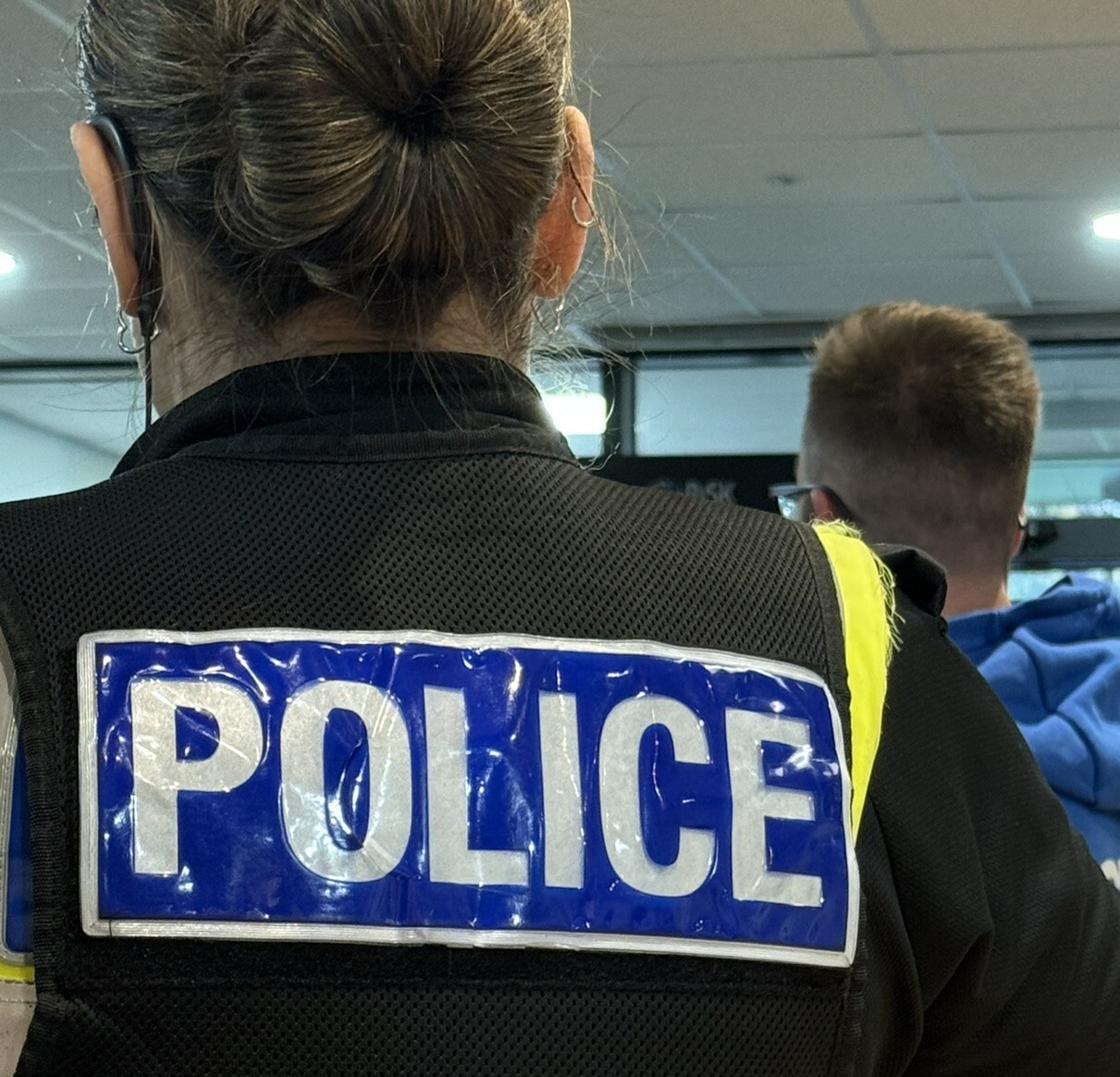 Photo of a Police Officer from behind - POLICE is visible on the back of her jacket