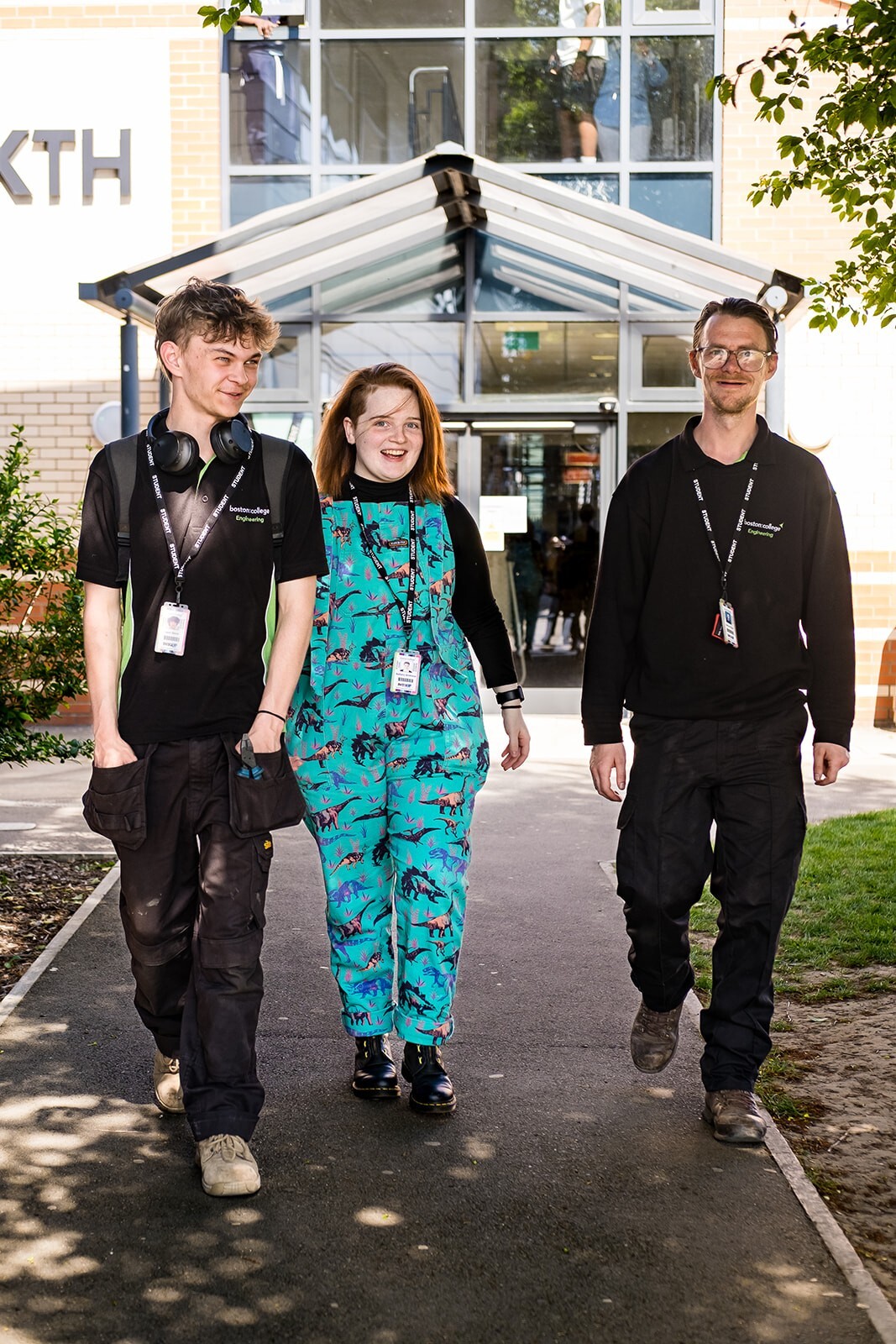 Three students walking through campus while talking.