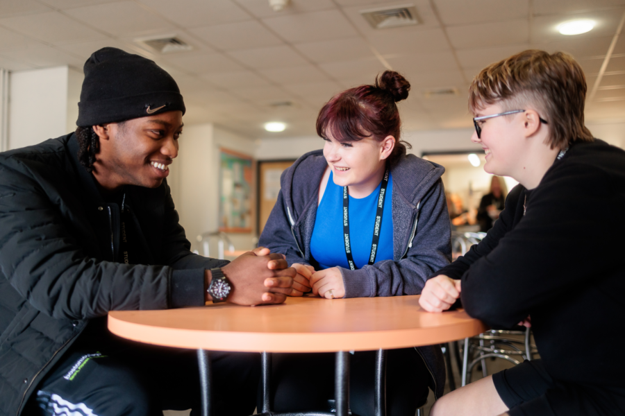 Students sat around a table talking.