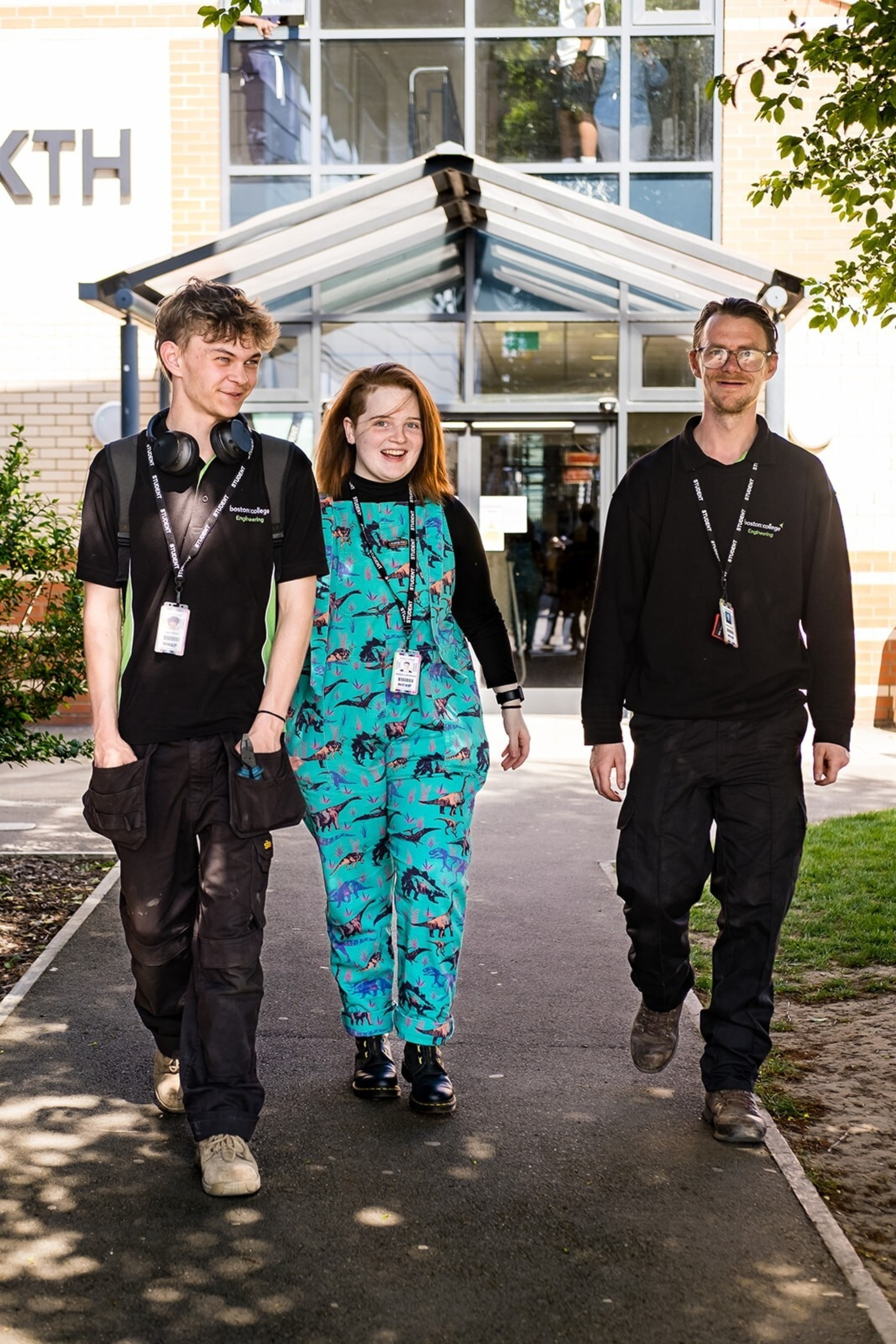 Three students walking through campus while talking.