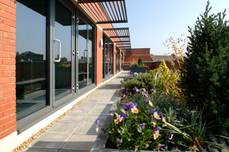Exterior of the Red Lion Centre in Spalding with glass windows and green foliage.