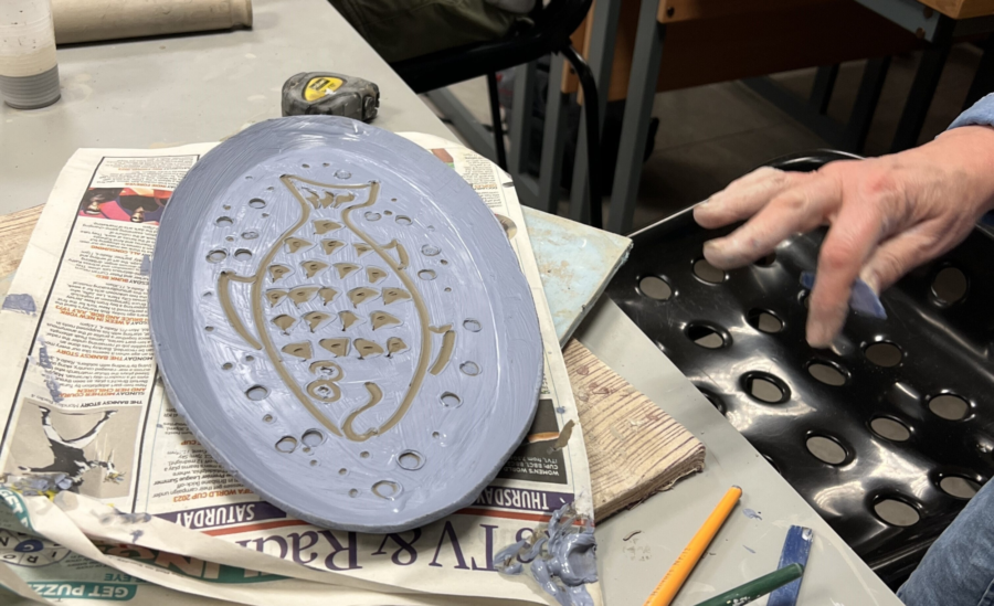 A decorated clay plate sat on newspaper.