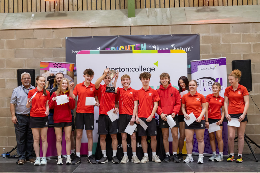 A group photo of 11 students from Bourne Grammar School lifting the Elite 11 trophy for 2025