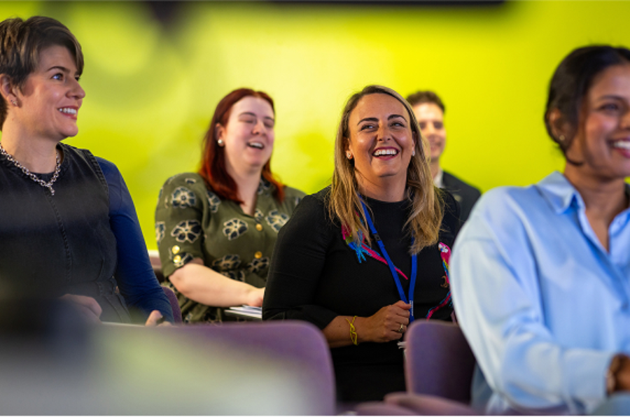 A group of students laughing and smiling in a lecture.